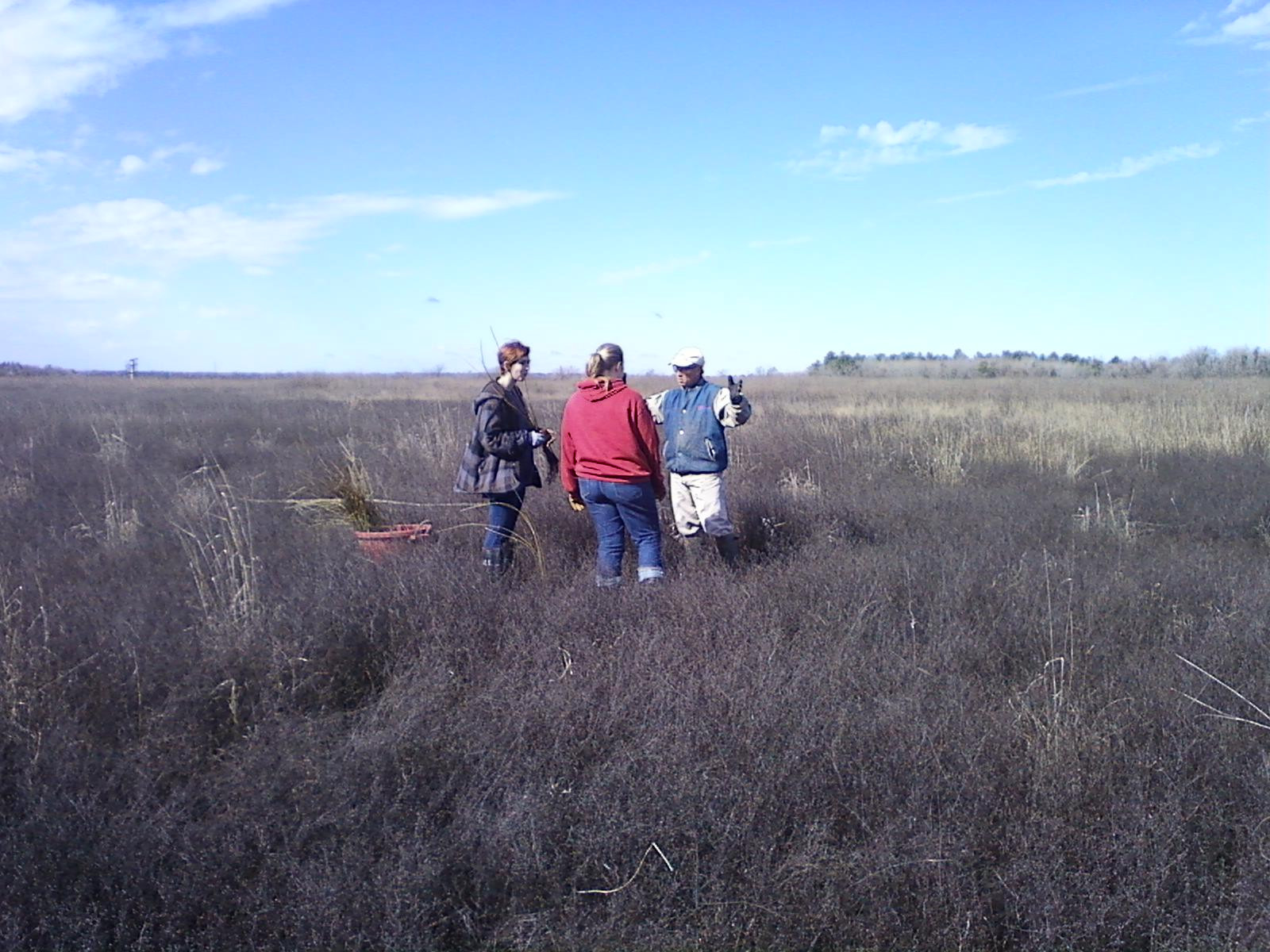 two girls learn about prairie planting from a volunteer