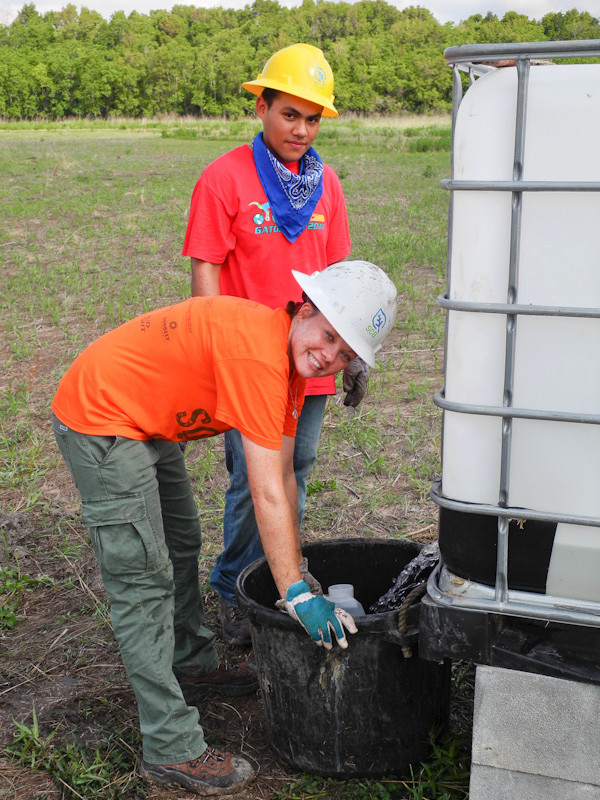 Two SCA Volunteers filling a water bucket