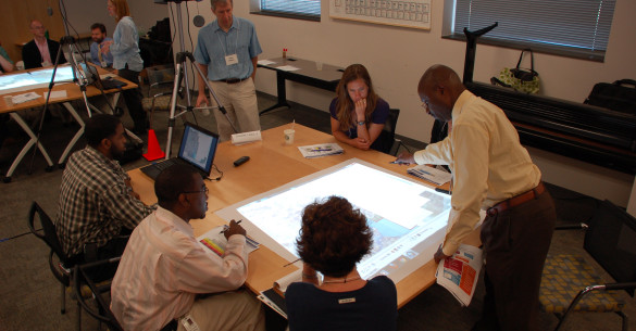 People sitting around a CHARM map using a weTable