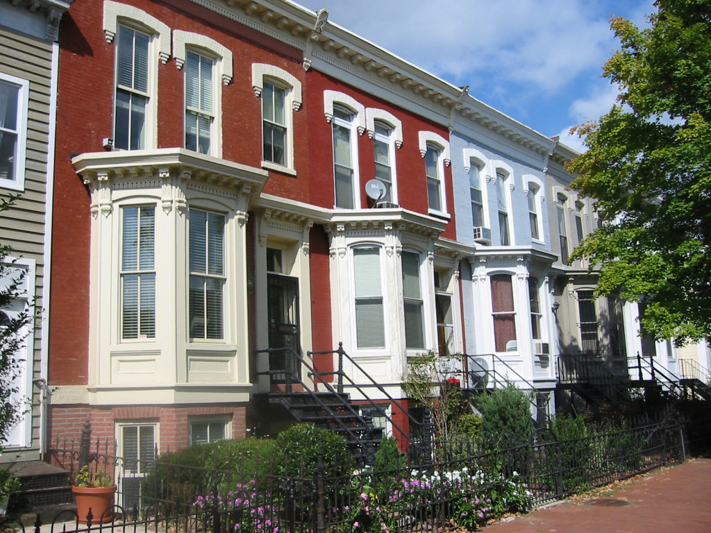 Colorful townhomes in a row with small gardens in the front